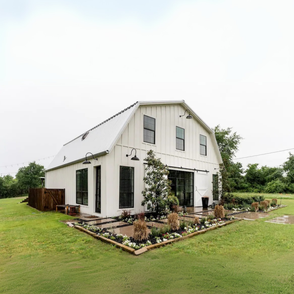 a white barn with a garden